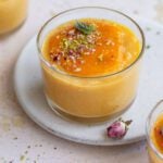 Coconut mango doodh poha served in three clear glass bowls.