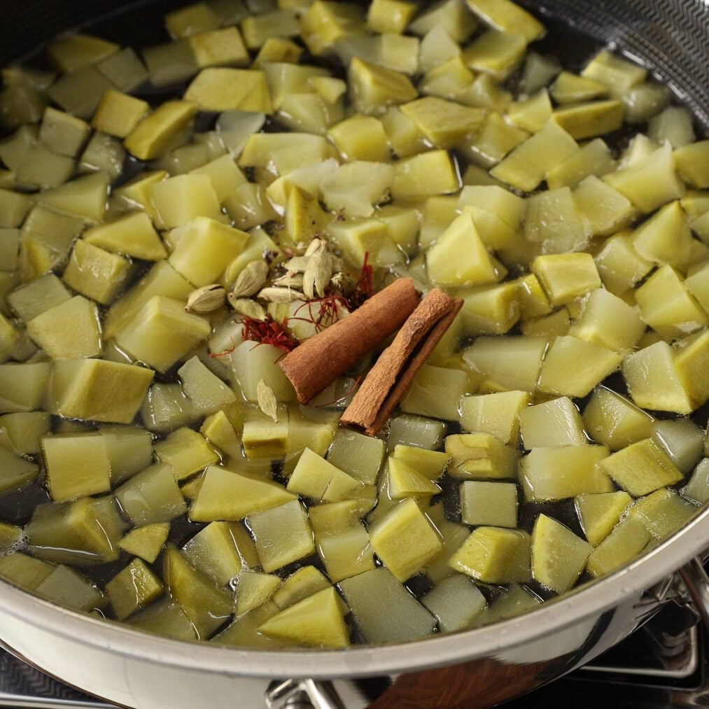 Boiled mango pieces and spices added to the one thread consistancy suger syrup.