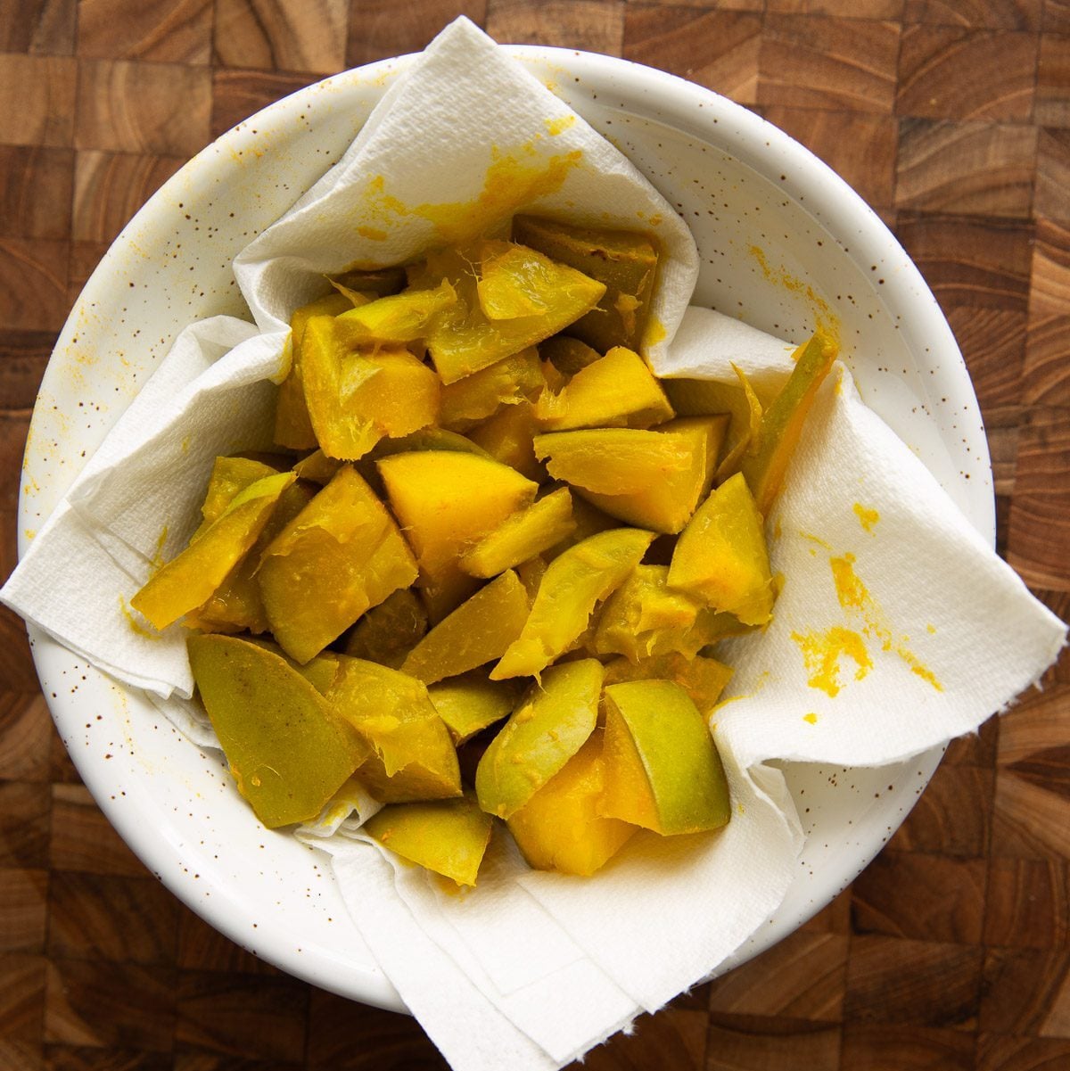 Steamed mango pieces on a kitchen paper in a bowl,
