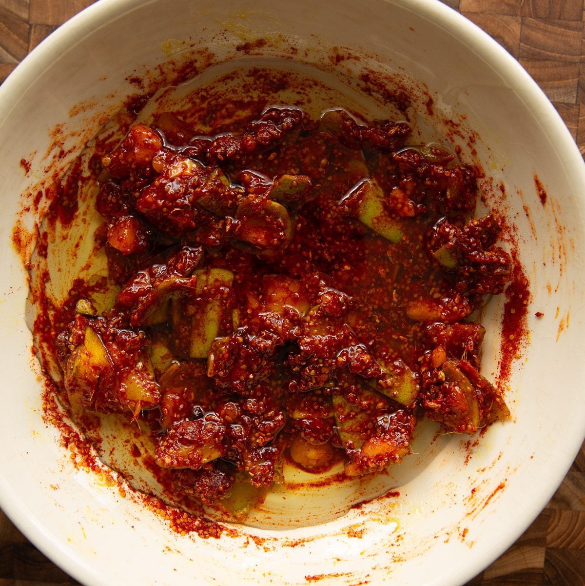 Oil added to the mango pickle in a bowl.