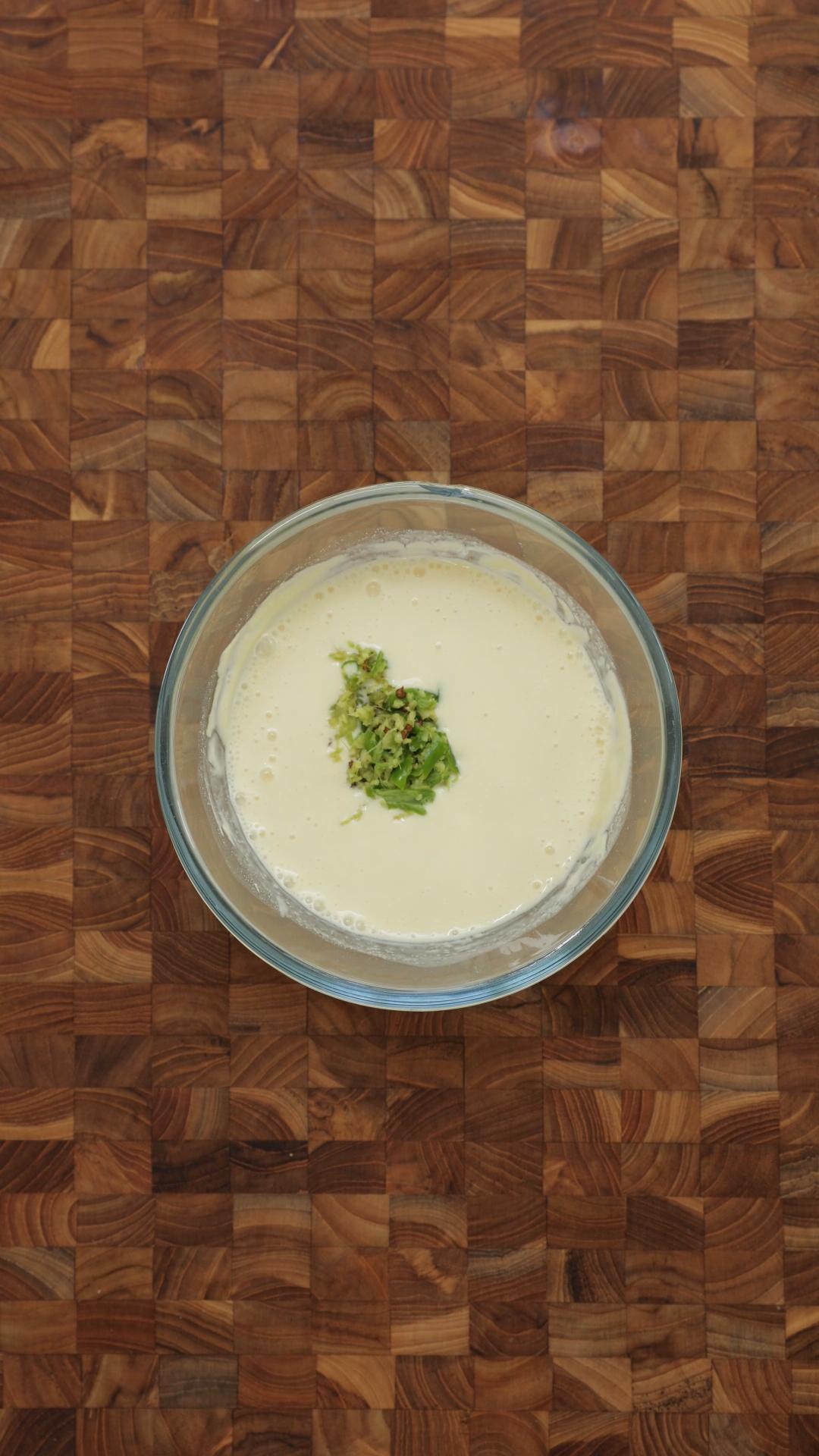 Crushed green chilli and ginger added to smooth yogurt and besan paste. 