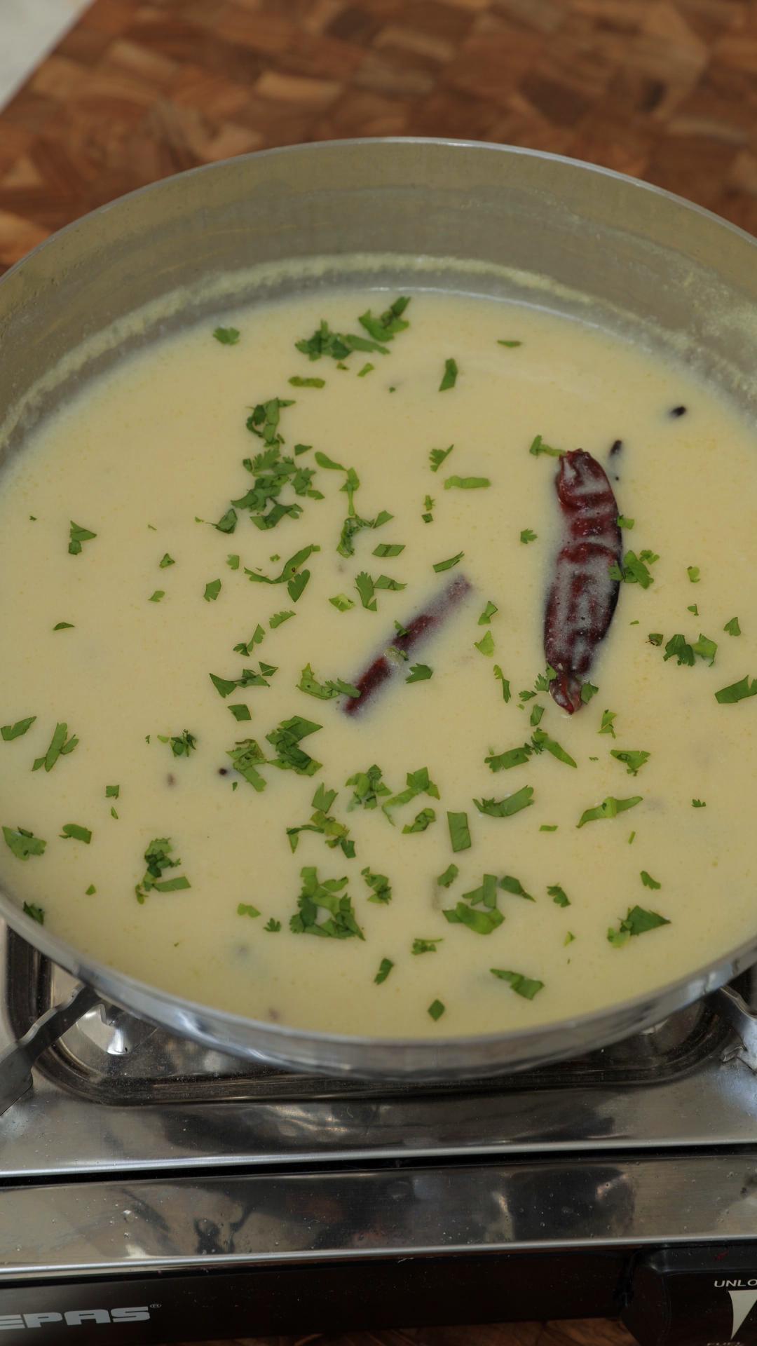 Finely chopped coriander garnished over white kadhi. 