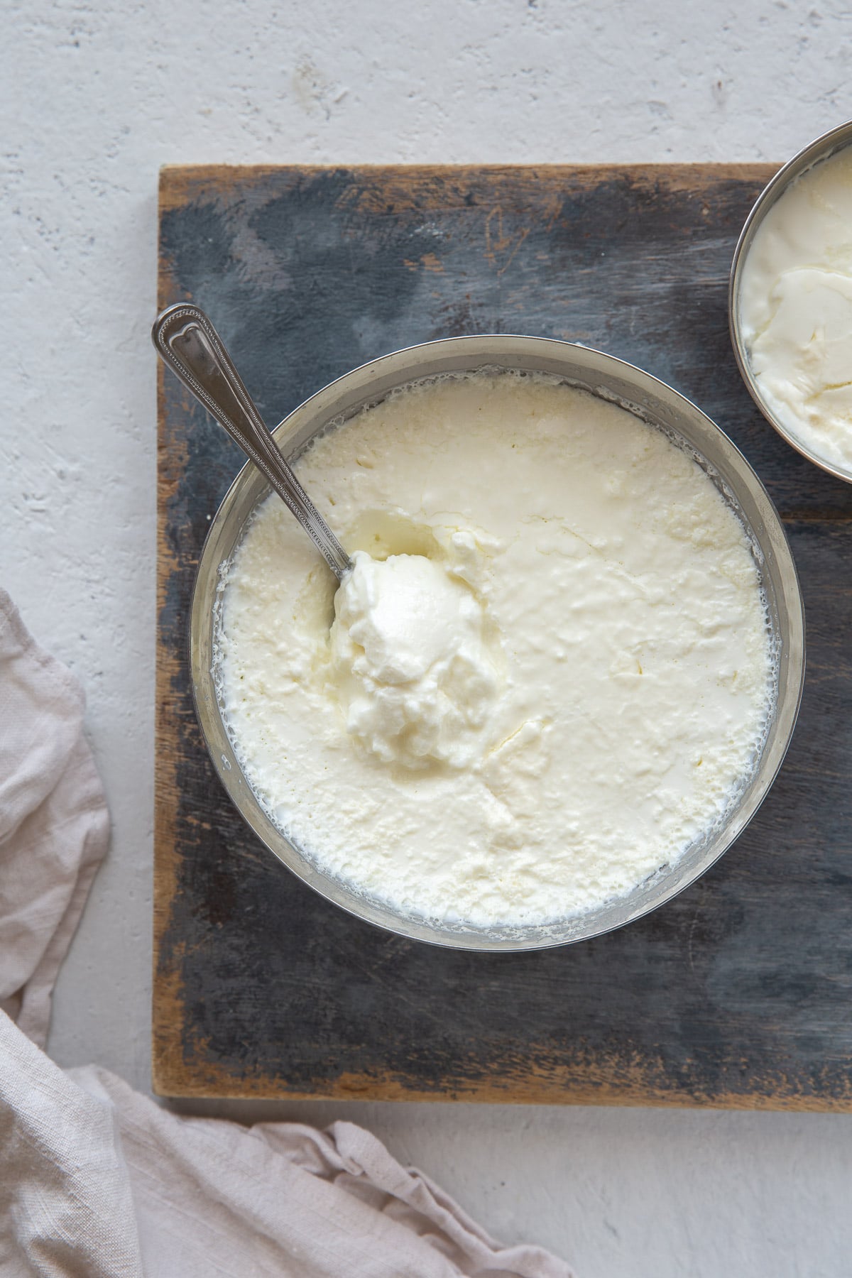 Plain thick set yogurt in a round stainless steel bowl. 