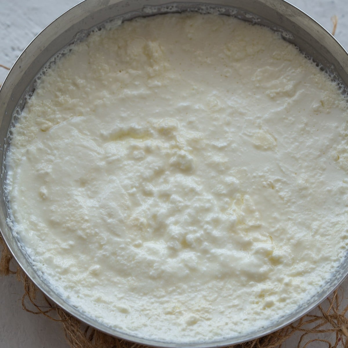 Thick set yogurt or curd in a stainless steel bowl. 
