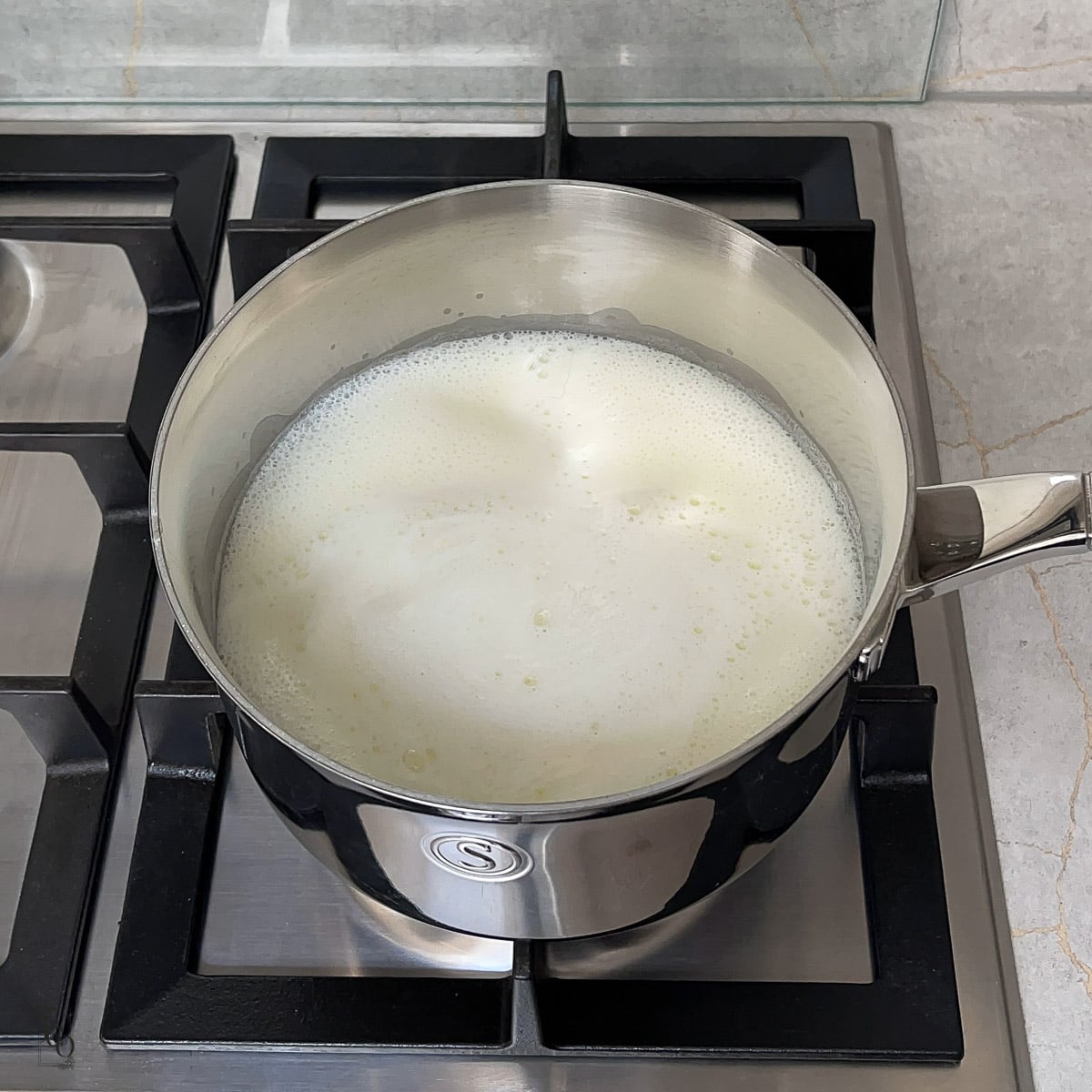 Saffron infused milk simmering in a pan.