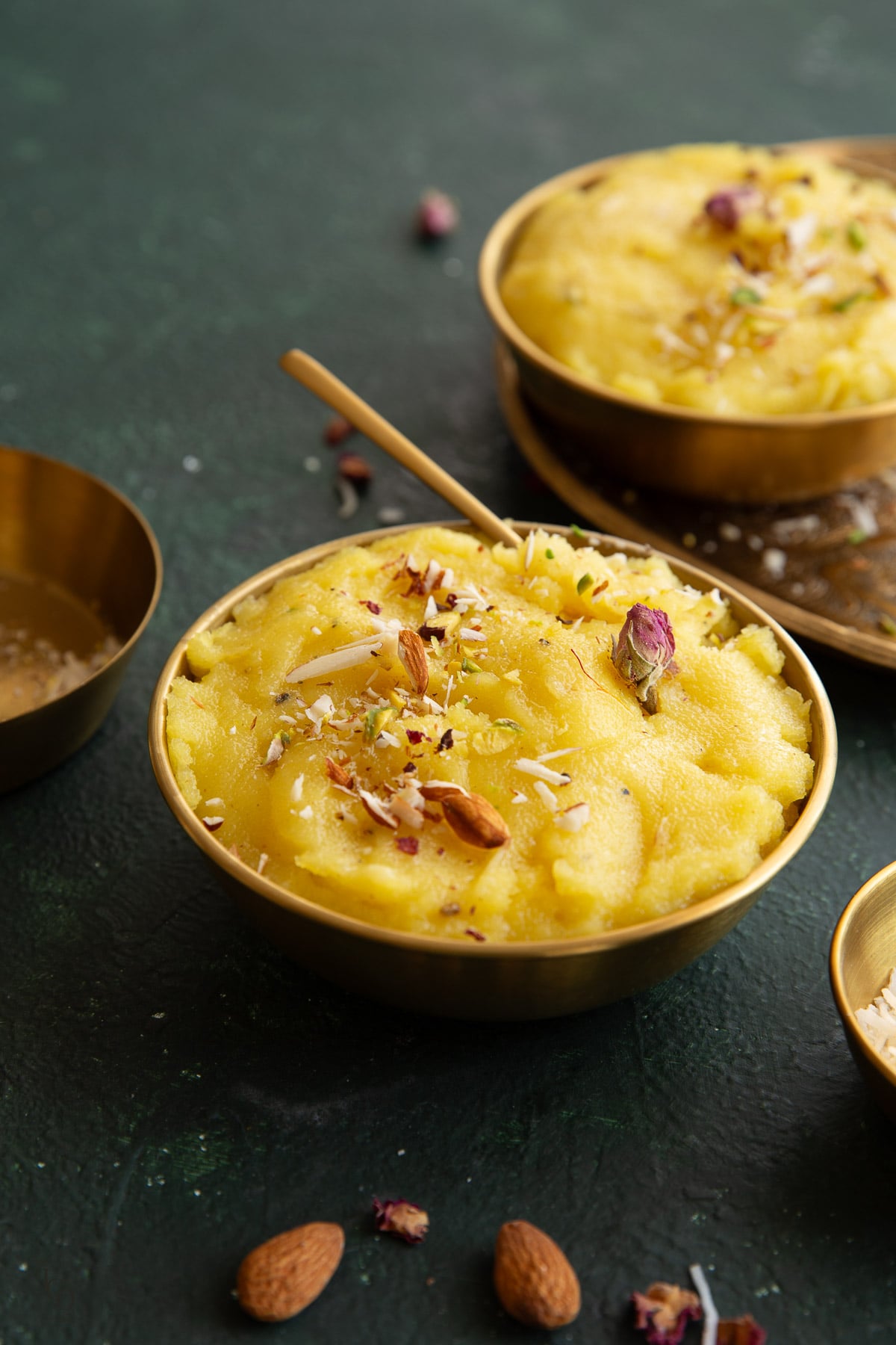 A gold bowl of halwa placed on green background.