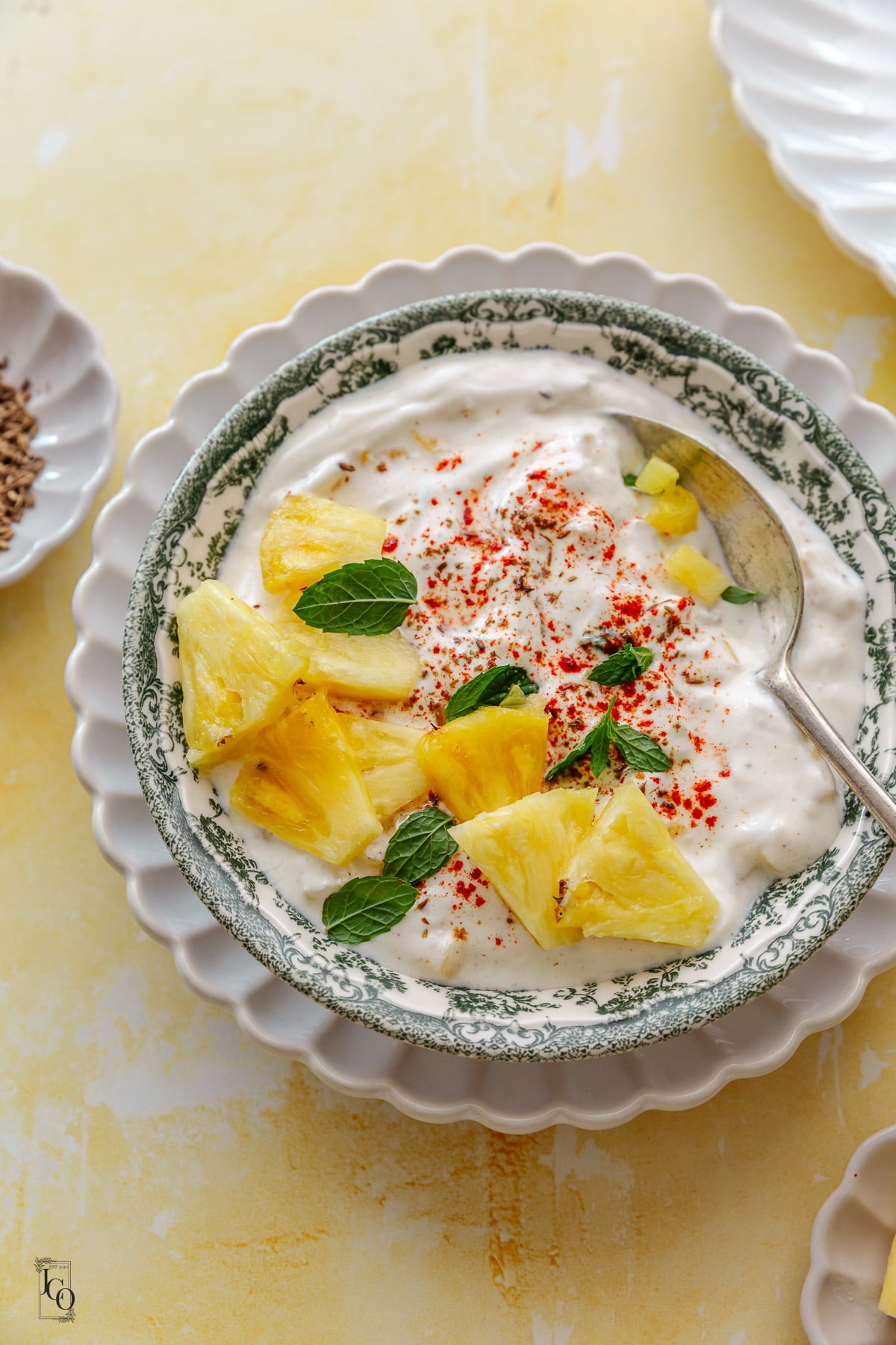 Ananas raita bowl placed on a white flute serving tray. 