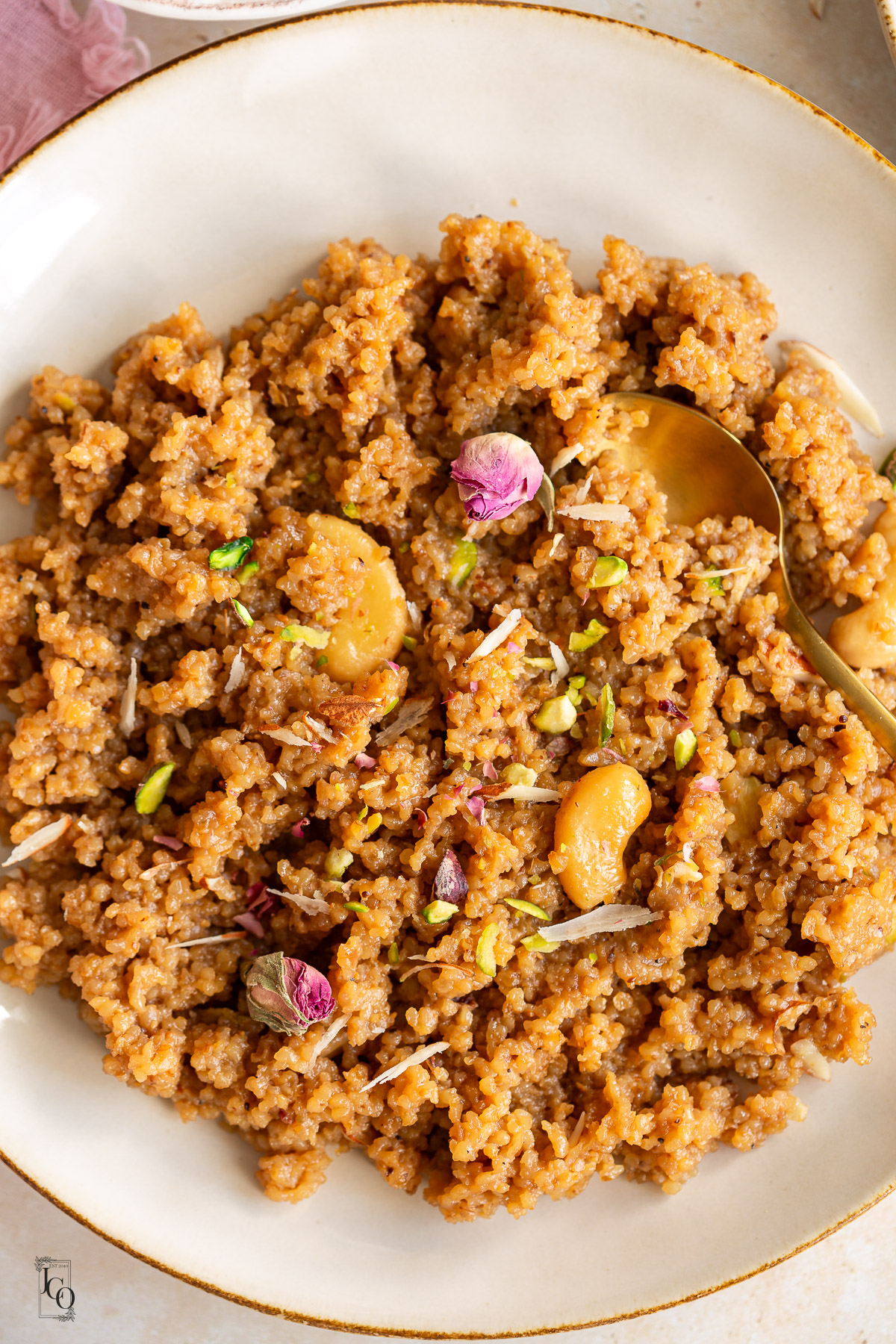 Caramel lapsi garnished with chopped nuts and dried rose petals.