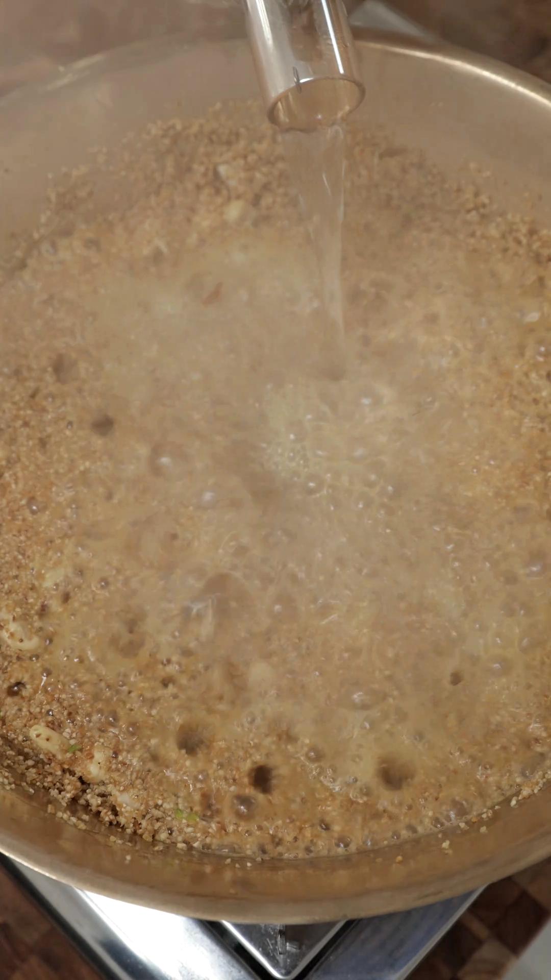 Boiling water added to the roasted broken wheat in a pan.