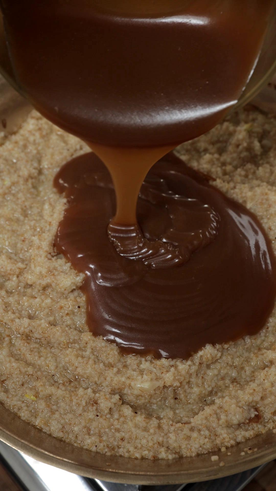 Caramel added to the cooked lapsi in a pan.