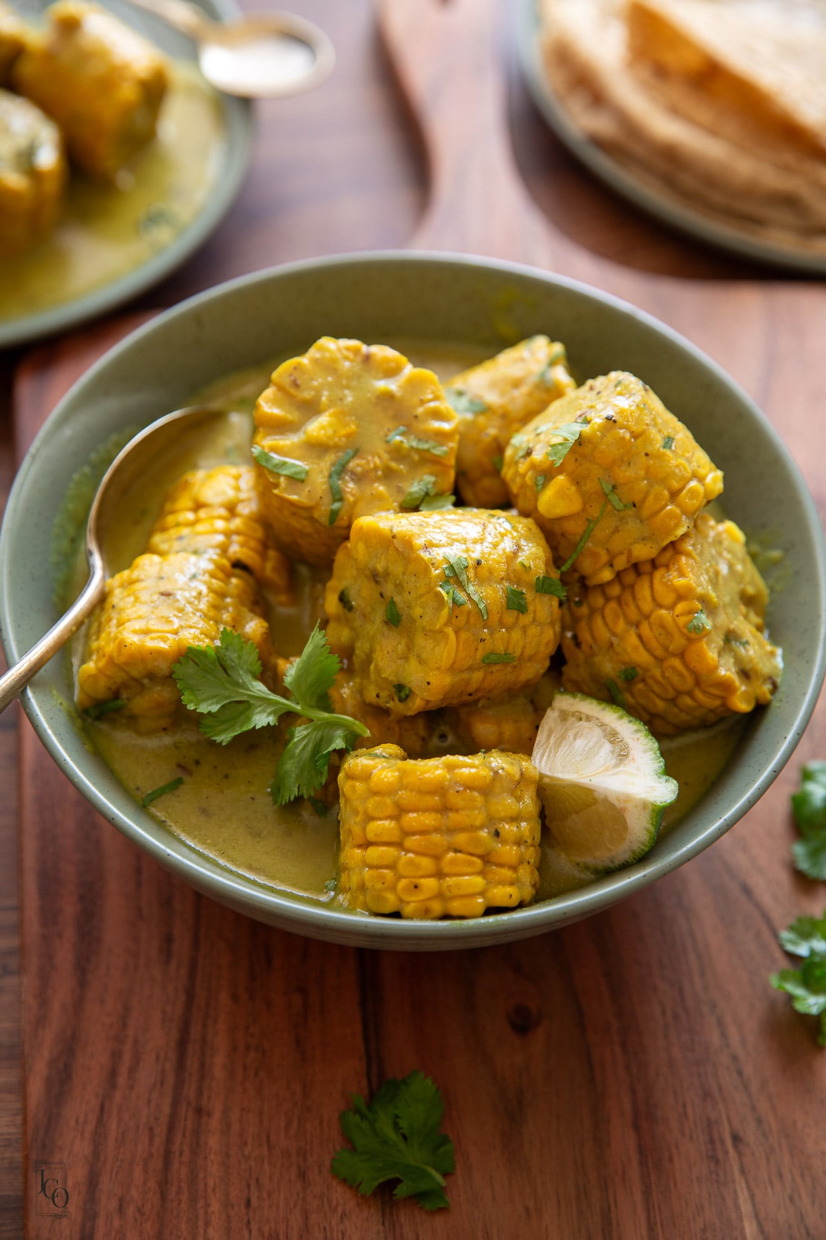 creamy corn on the cob and coconut curry garnished with chopped coriander and served with roti.