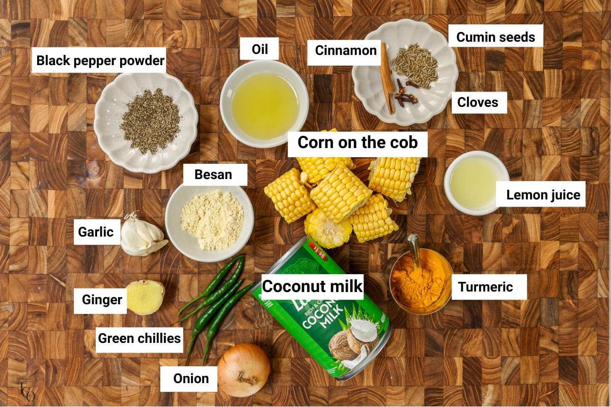 Corn cob, spices, oil and coconut milk on the brown surface.