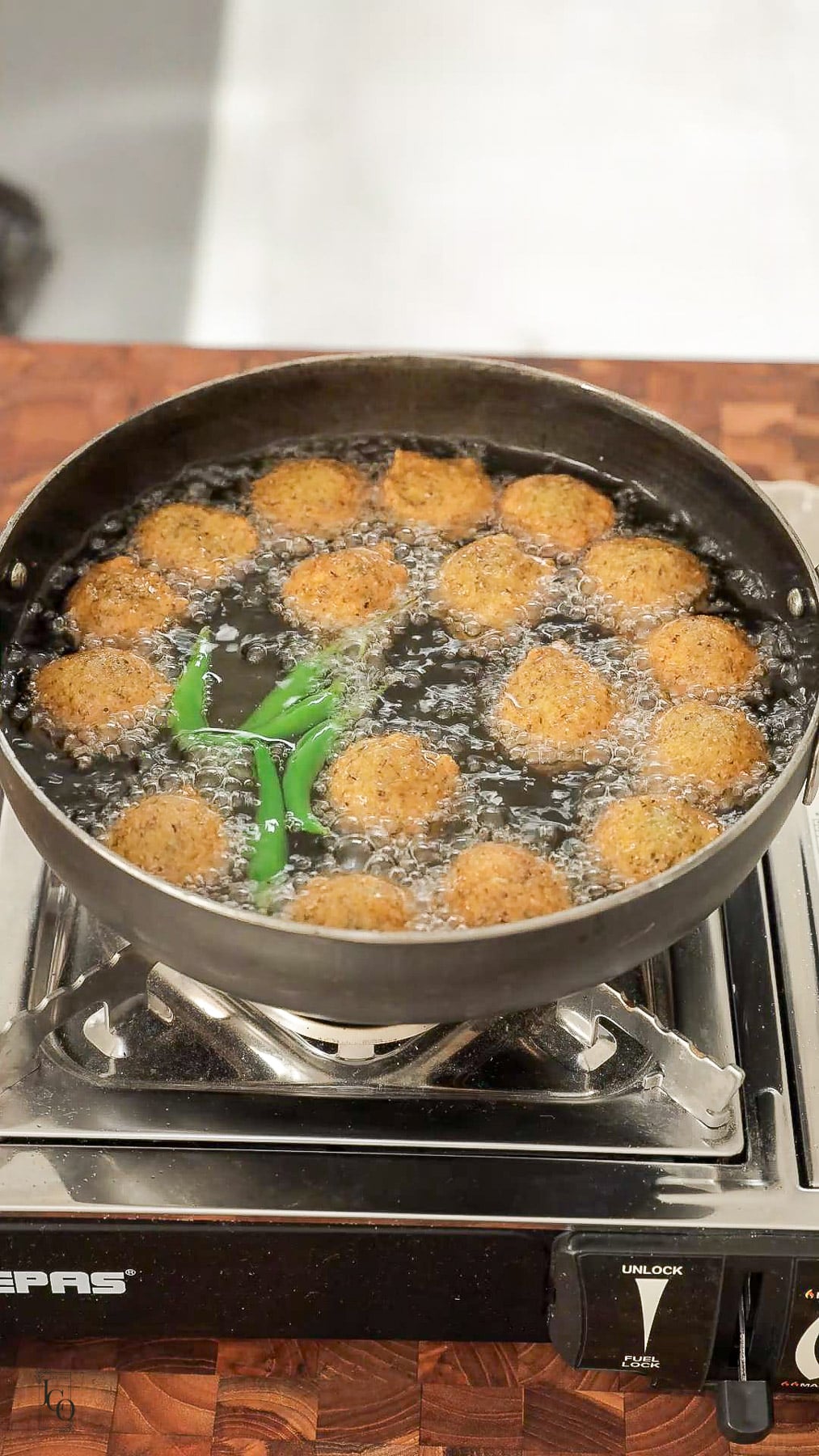 Gujarati dal vada deep frying with green chillies and turning in brown colour. 