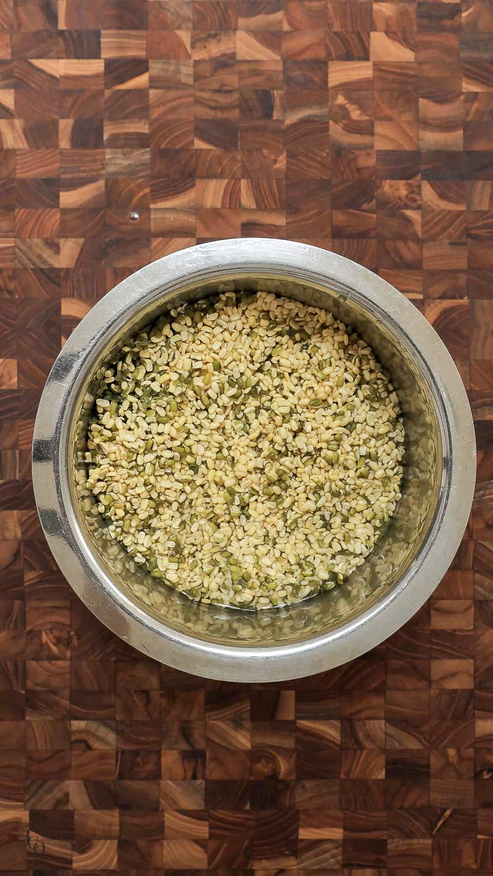 Soaked green moong dal in a pan. 