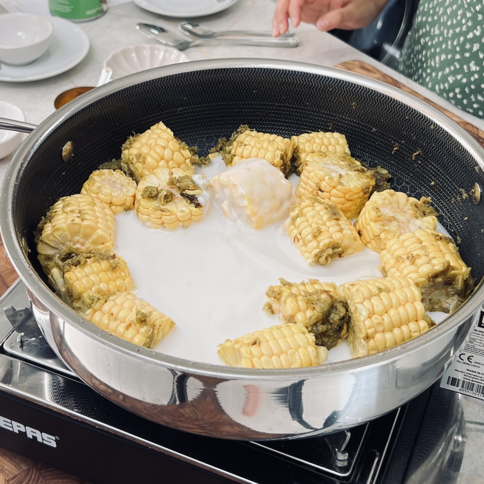Pieces of corn cobs and coconut milk in a pan.
