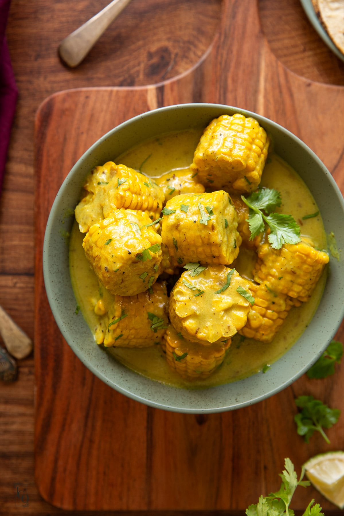 Sweet corn and coconut curry served in a light green serving bowl.