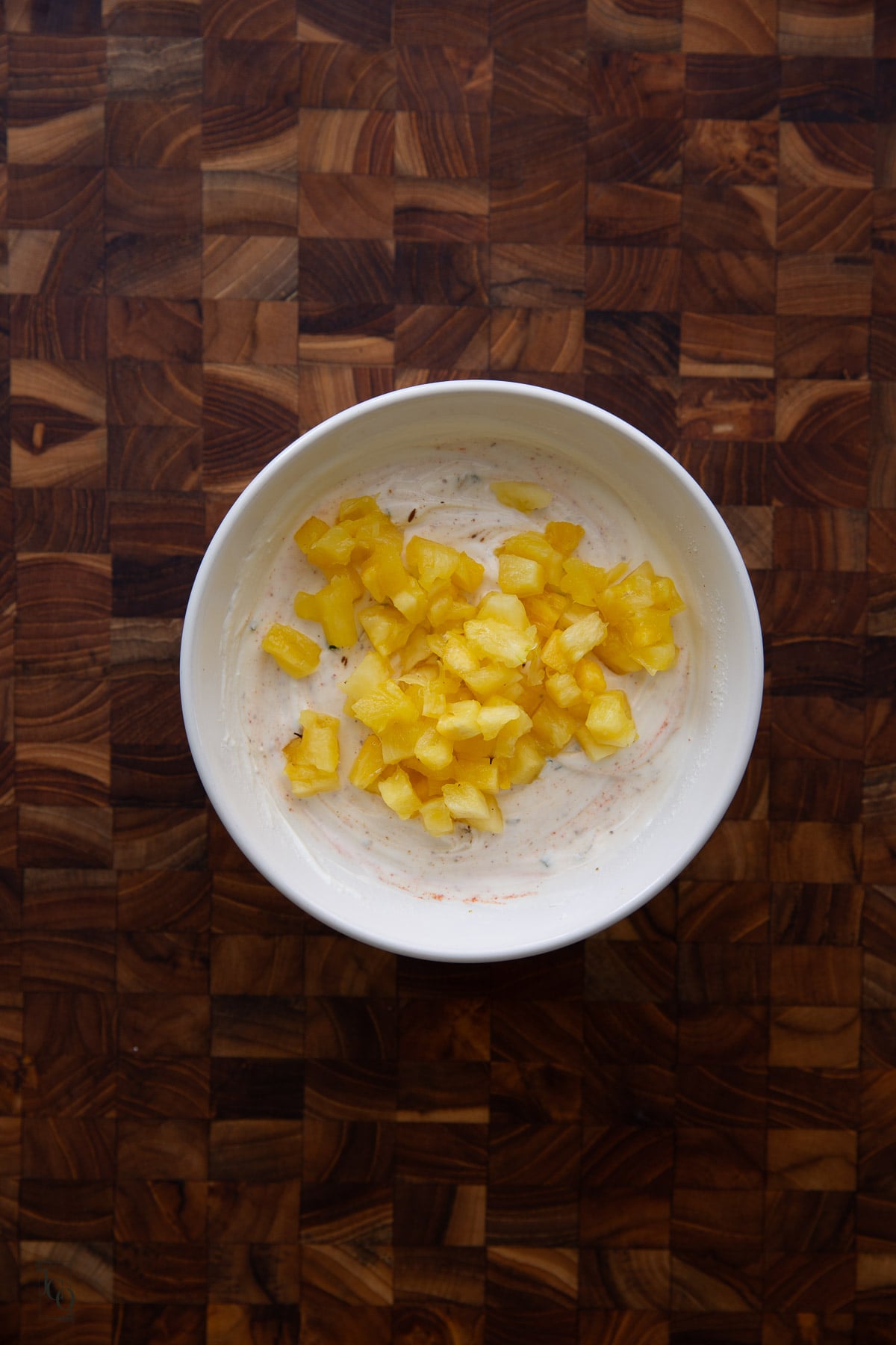 Finely chopped pineapple pieces added to the spiced whisked yogurt. 