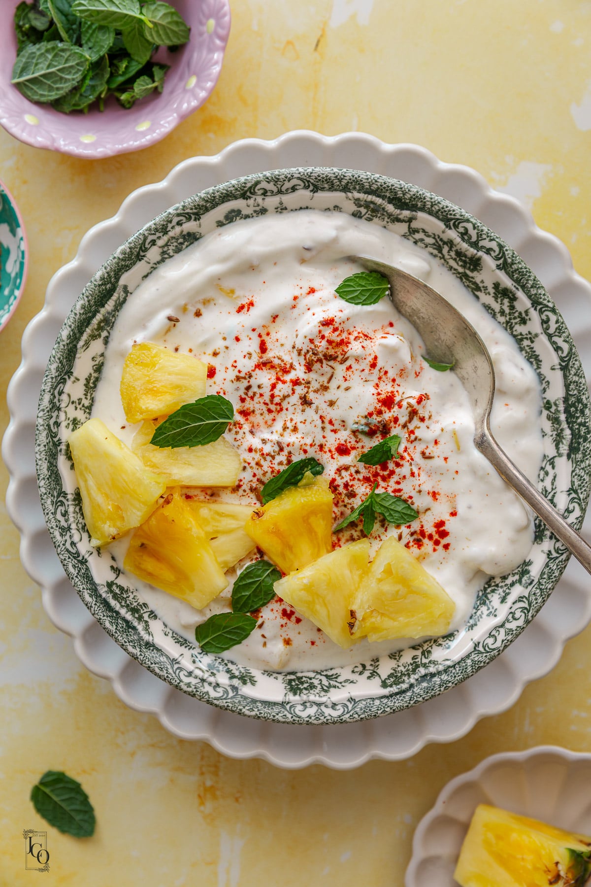 Pineapple raita served in a green decorative serving bowl. 