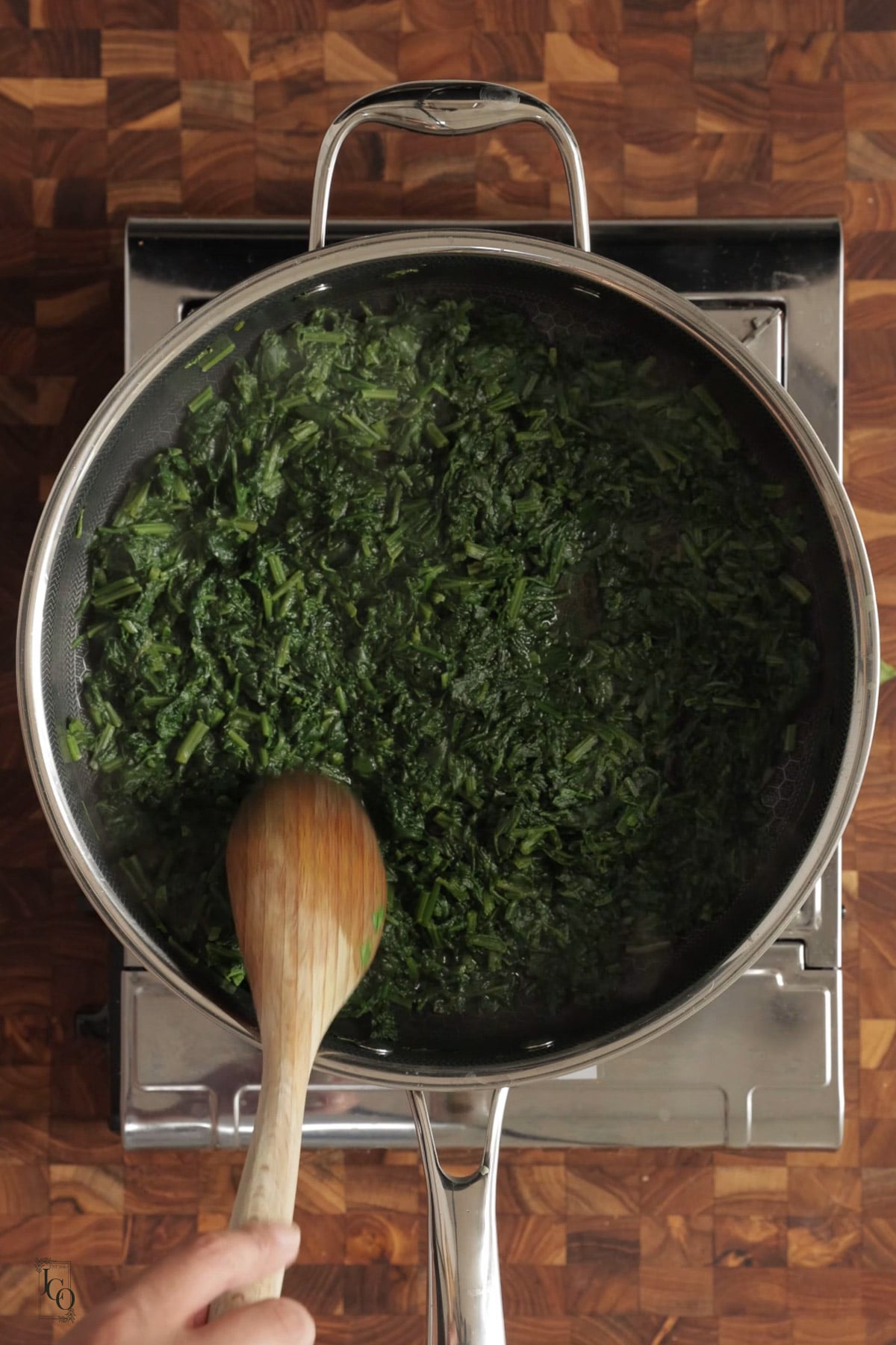 Spinach cooking with water in a pan.