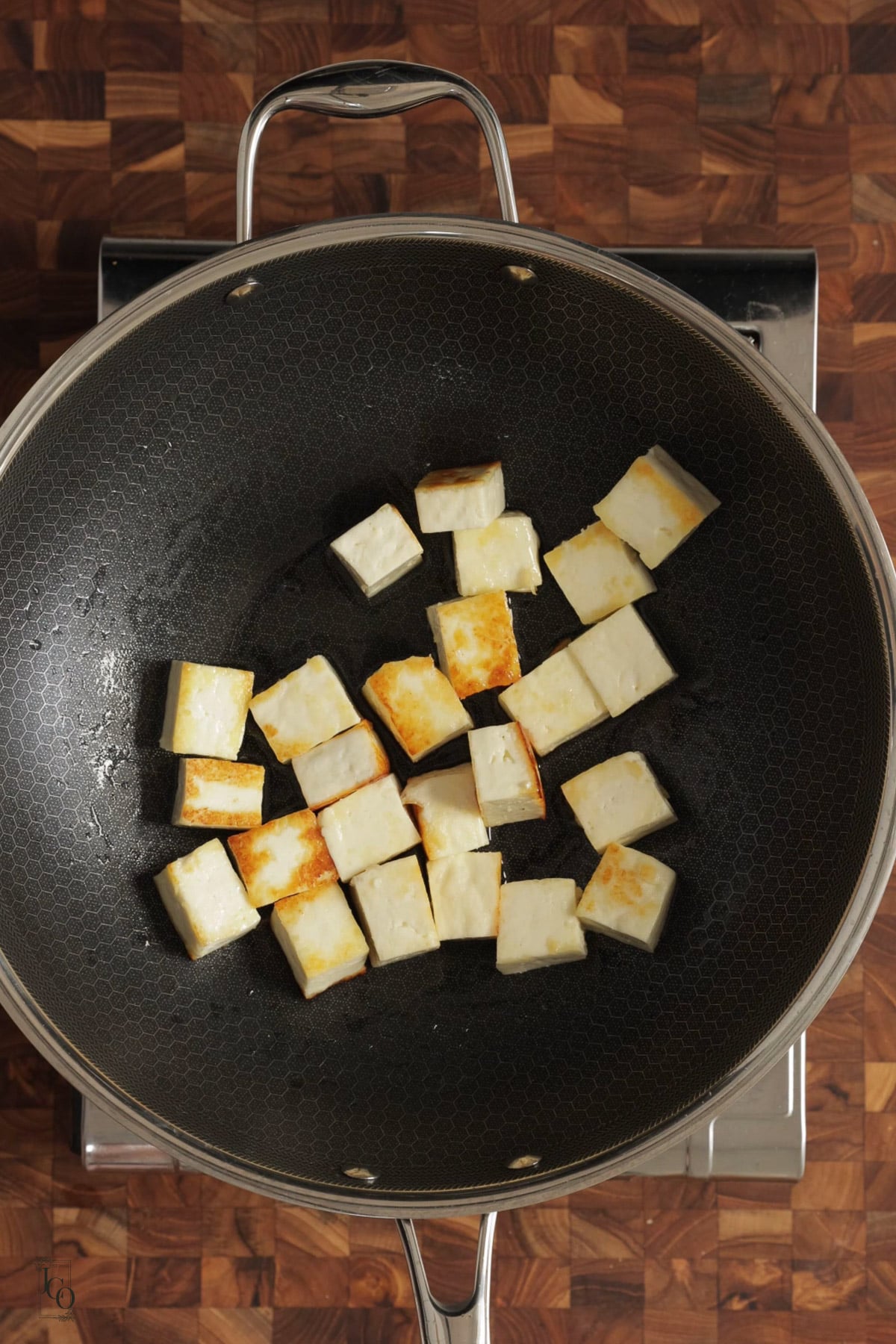 Light brown sauteed paneer cubes in a pan.