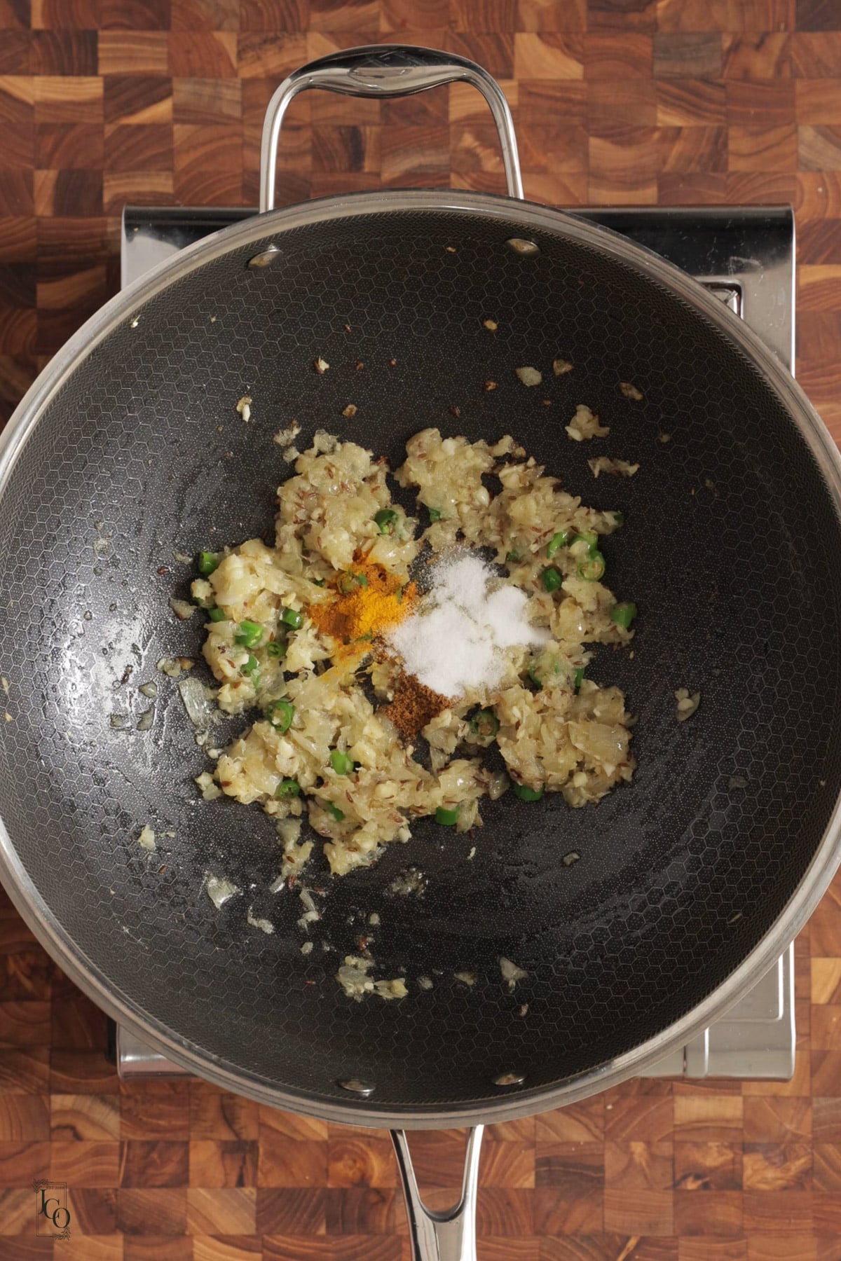 Cooked onion masala with spices in a pan.