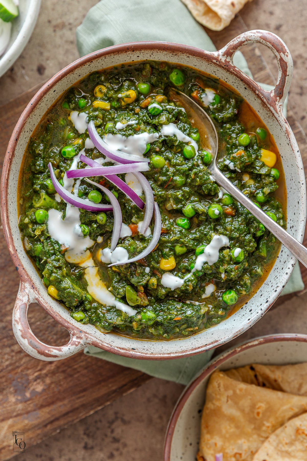 vegetable palak curry served in a beige serving bowl.