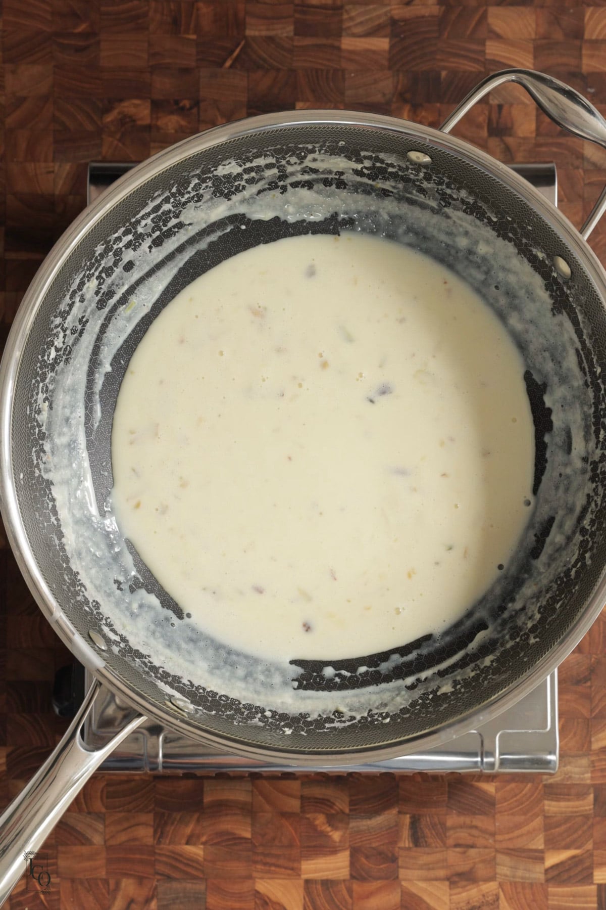 Thickened milk dessert with nuts in a pan.