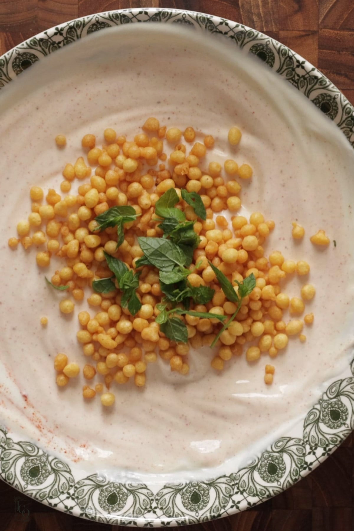 Boondi and mint leaves added to spiced yogurt.