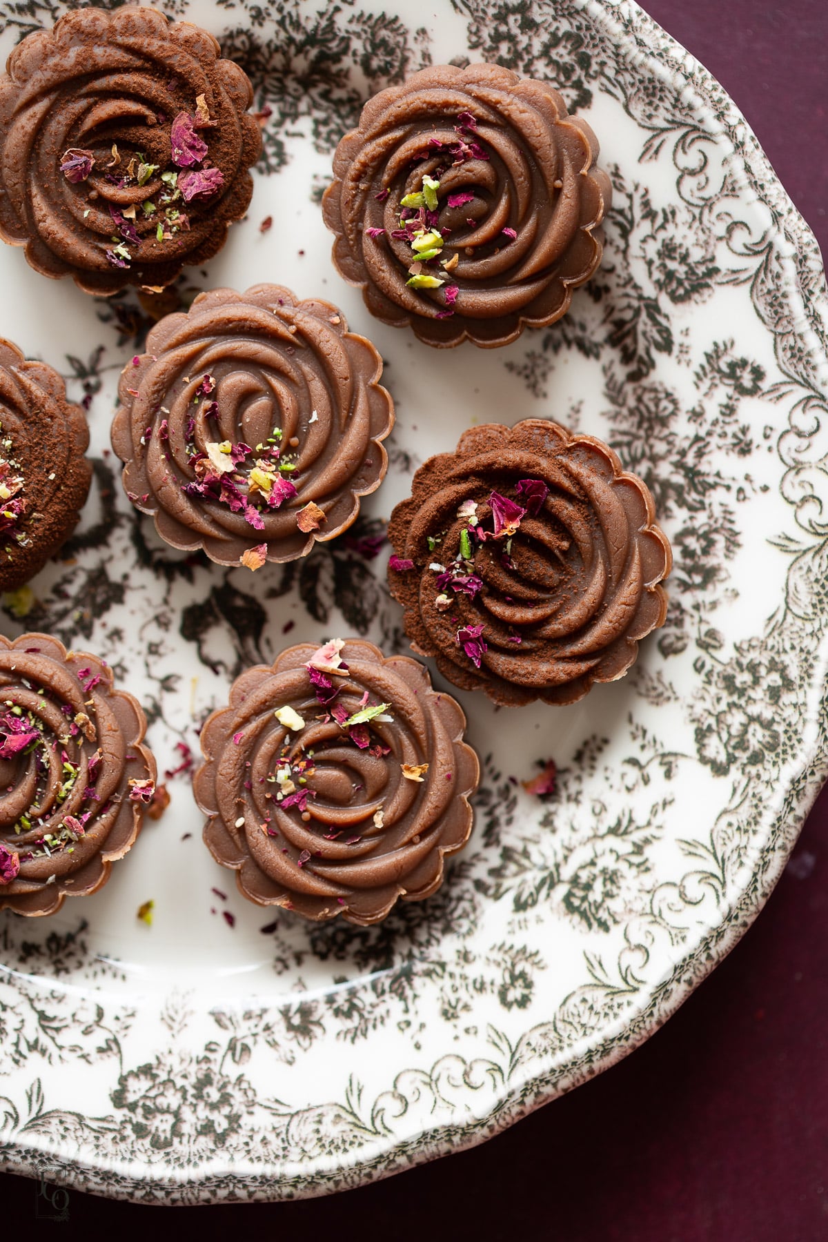 Chocolate peda decorated with rose petals, pistachios and cocoa powder. 