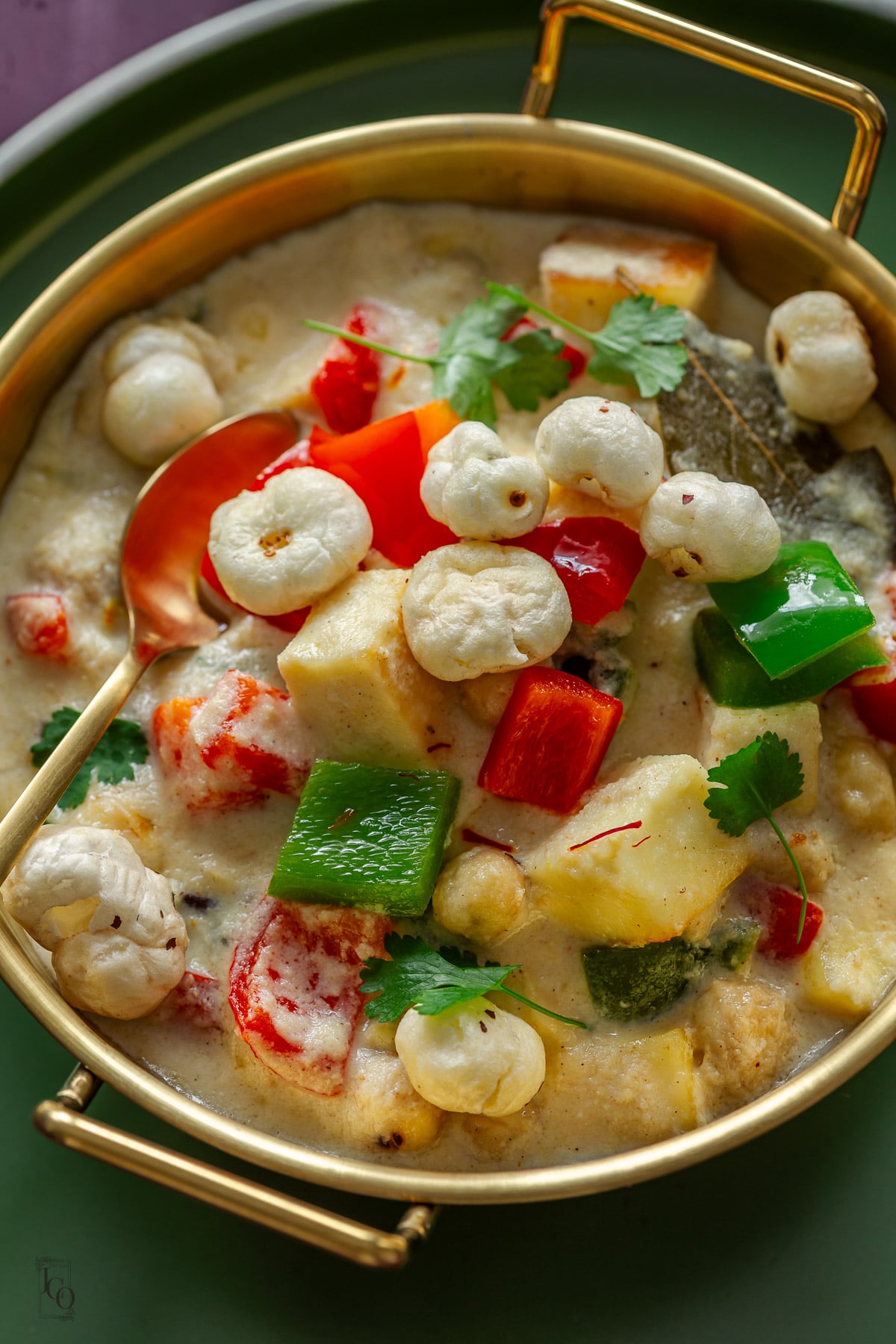 farali paneer makhana curry served in a gold bowl with a spoon.