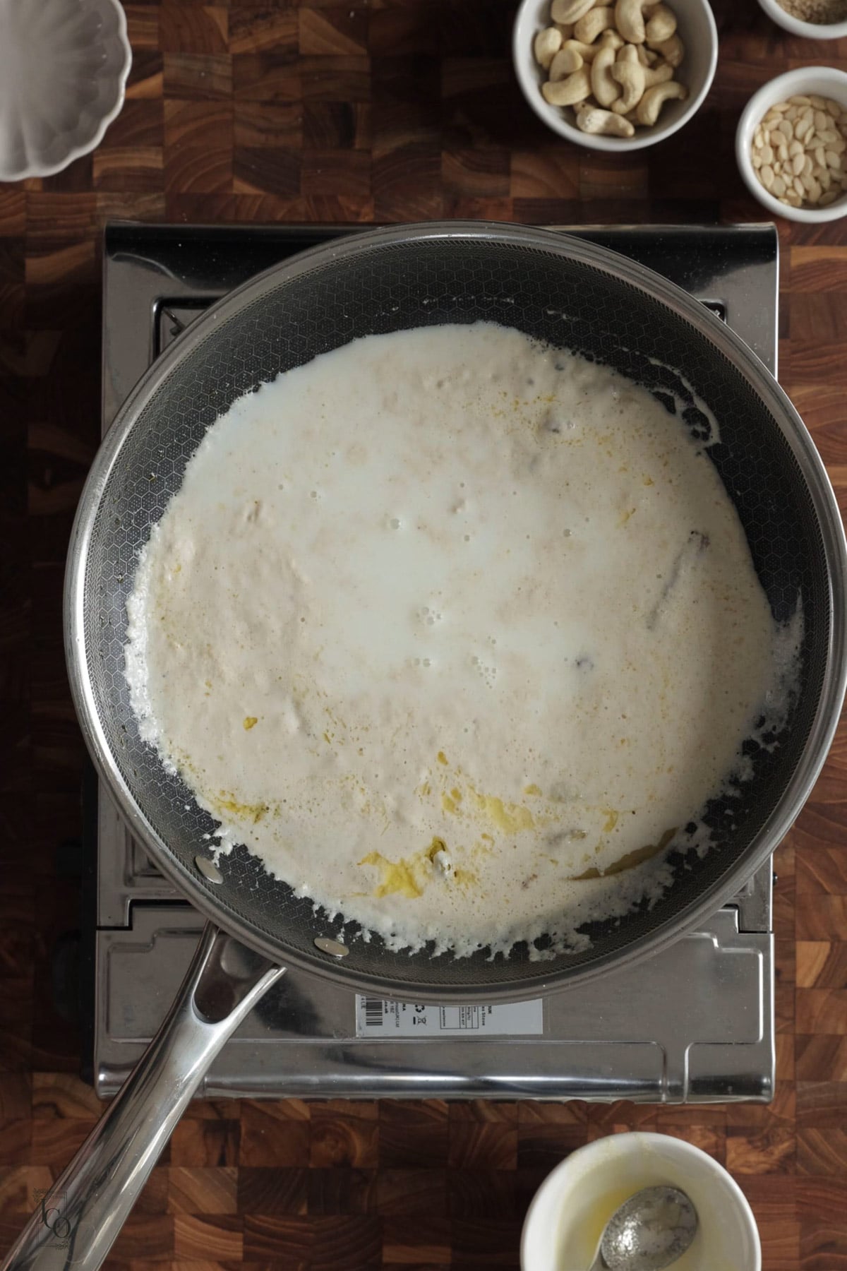 Milk added to cashew nuts gravy in a pan.