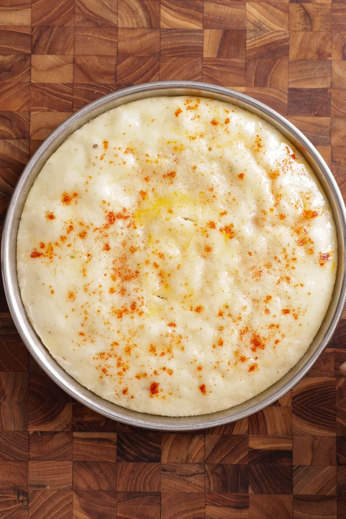 Steamed rava dhokla thali cooling on a brown surface.